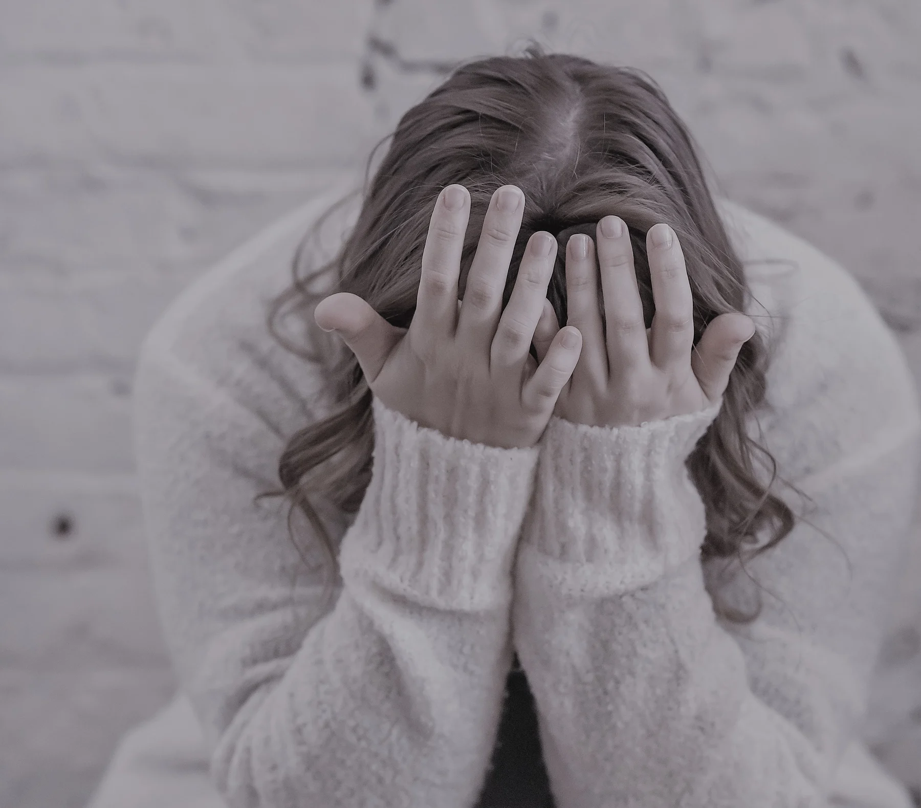 A person sitting with their face in their hands