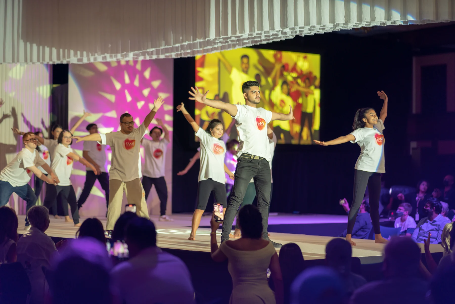 A group performing together on a brightly lit stage