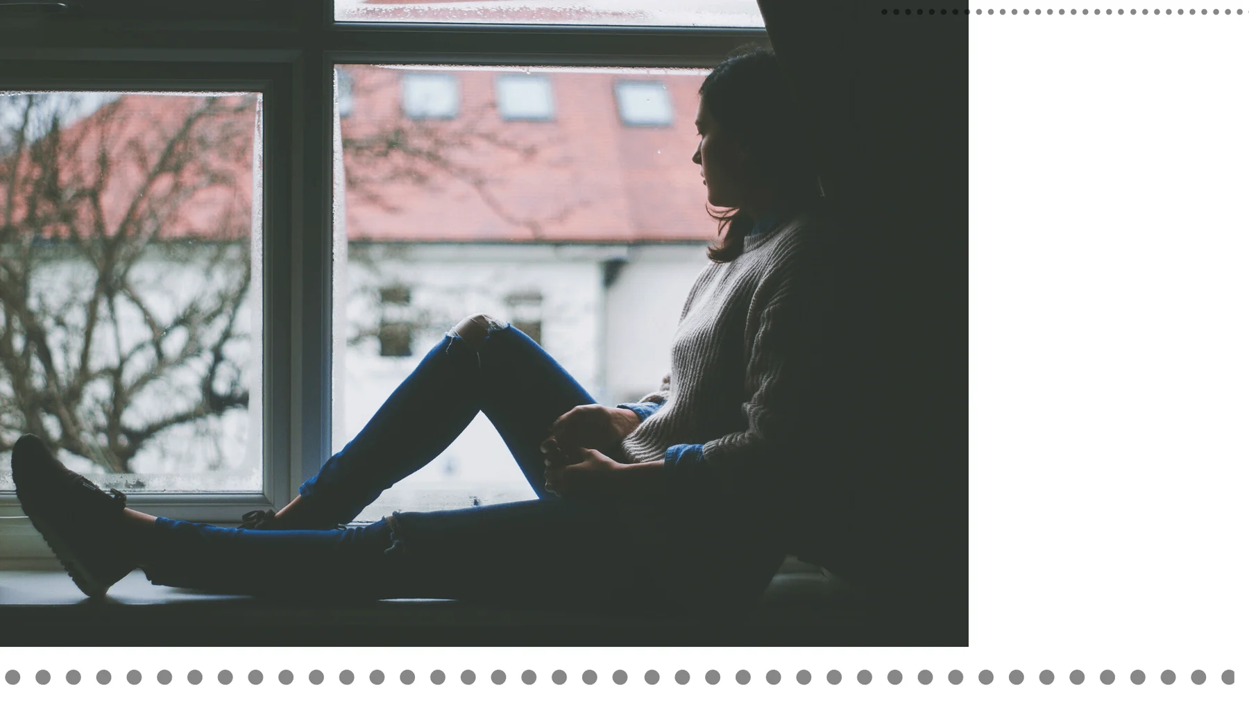 A person sitting beside a window with an open notebook
